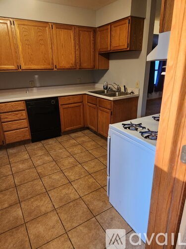 A kitchen with brown cabinets and a white fridge.