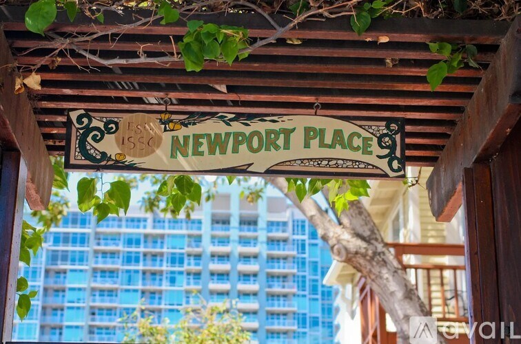A sign that says Newport Place is hanging from a wooden structure.
