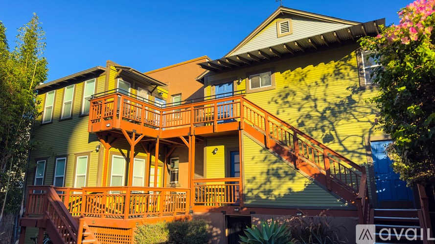 A house with a green and orange exterior and a balcony.