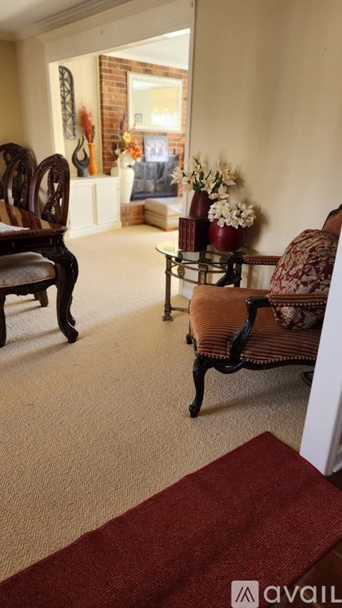 A living room with a brown chair and a red rug.