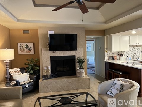 A living room with a fireplace and a television mounted above it.