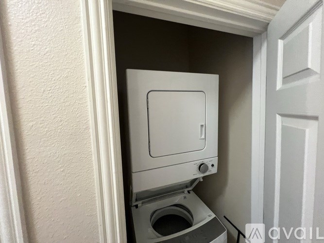 A white toilet is installed in a small space between a wall and a door.