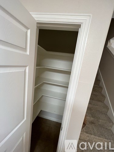 A stairway with a carpeted runner and white walls.