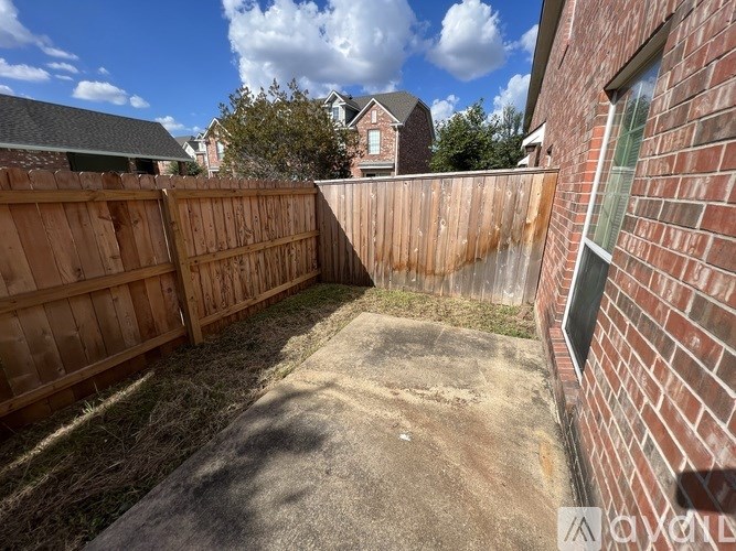 A backyard with a wooden fence and a brick wall.