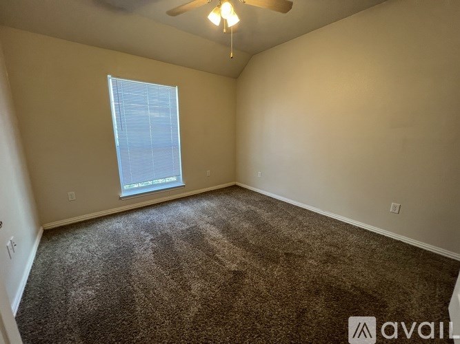 A room with a carpeted floor and a window.