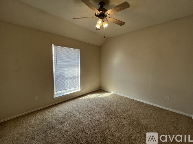 A room with a ceiling fan and carpeted floor.