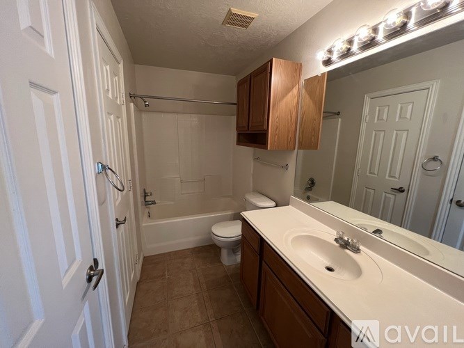 A bathroom with a toilet, sink, and mirror.