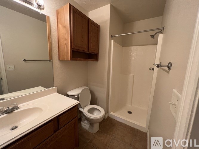 A bathroom with a toilet, sink, and shower.