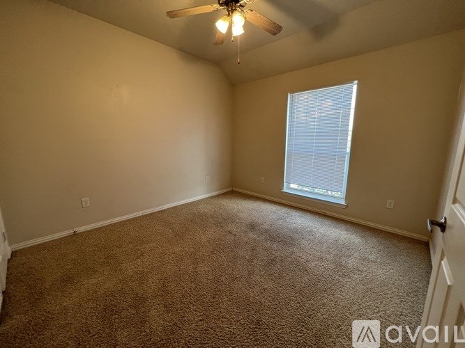 A room with a carpeted floor, a ceiling fan, and a window with blinds.