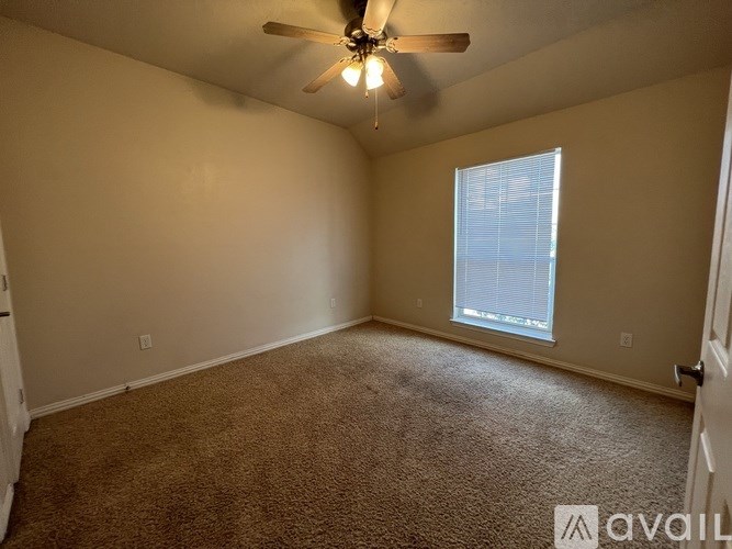 A room with a carpeted floor and a ceiling fan.