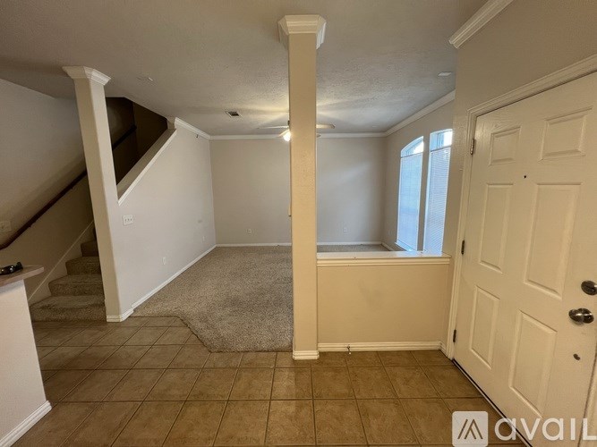 A room with a carpeted floor and a door on the right side.