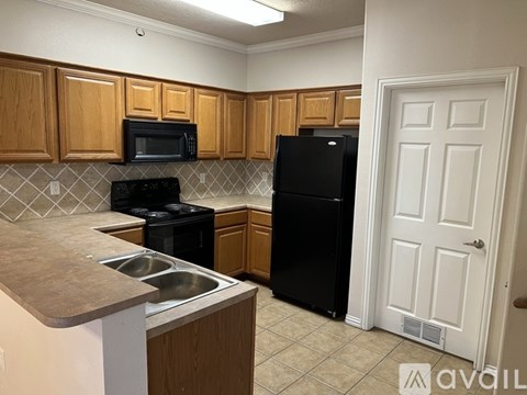 A kitchen with wooden cabinets and black appliances.