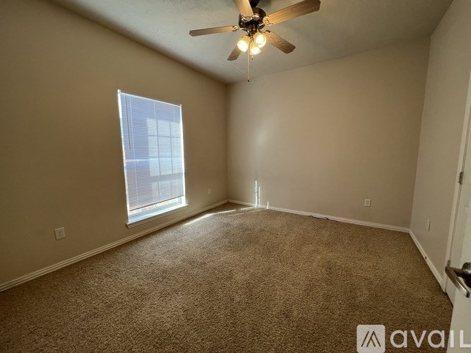 A room with a ceiling fan and carpeted floor.