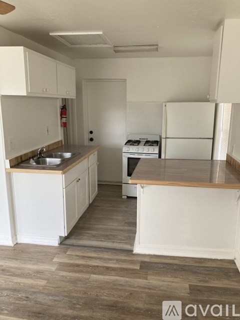 A kitchen with white cabinets and a wooden countertop.