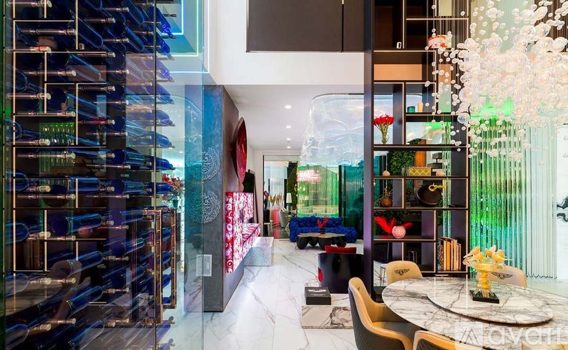 A modern dining area with a glass wall separating the kitchen from the dining area.