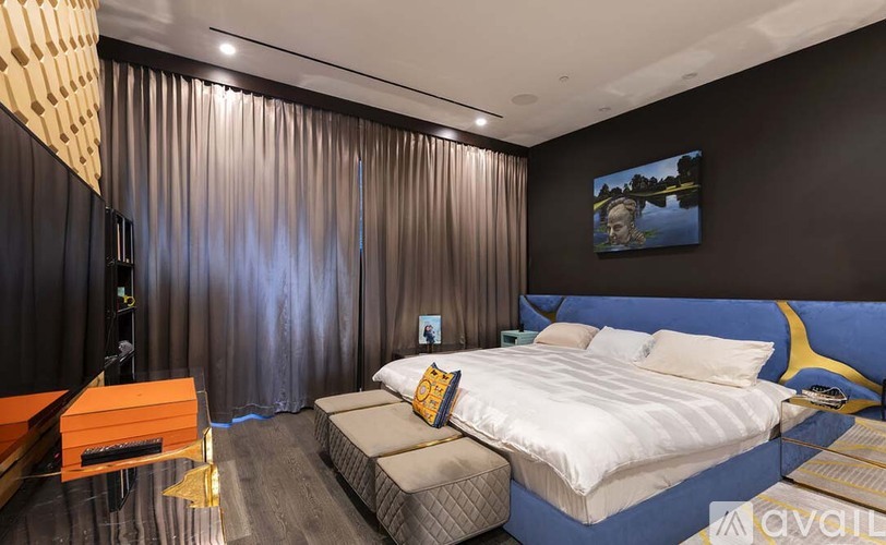A modern bedroom with a large bed and a television.