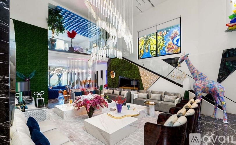 A living room with a white sofa and a painting on the wall.