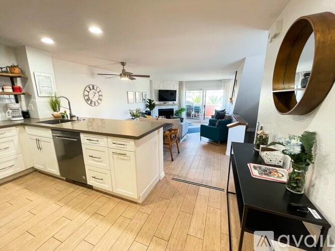 A kitchen with wooden floors and white cabinets.
