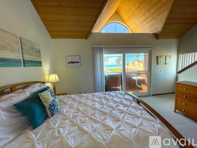 A bedroom with a large bed and a wooden ceiling.