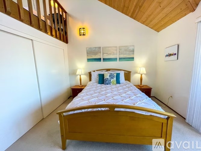 A bedroom with a large bed and a wooden headboard.