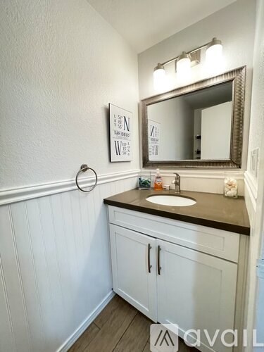 A bathroom with a white sink and a mirror above it.