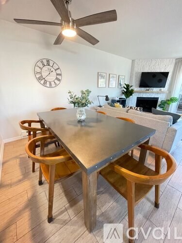 A dining room with a table and chairs.