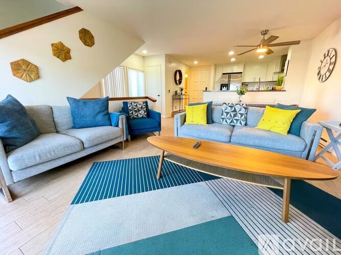 A living room with a grey couch and a wooden coffee table.