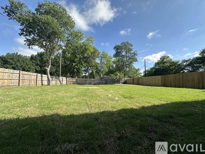 A backyard with a fence and trees.