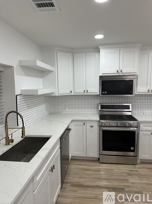 A kitchen with white cabinets and a black oven.