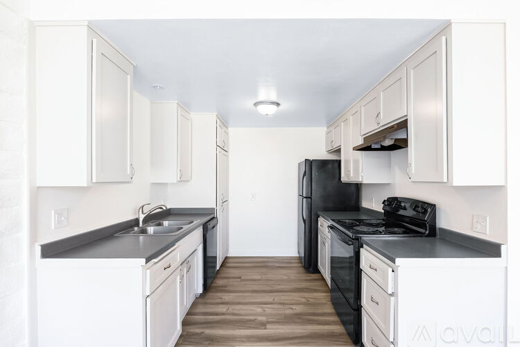 A kitchen with black appliances and white cabinets.