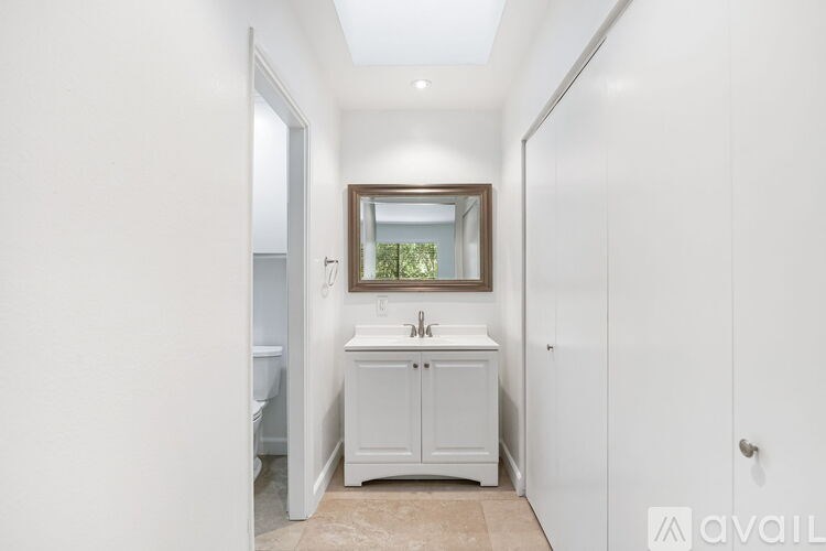 A bathroom with a white cabinet and a mirror above the sink.