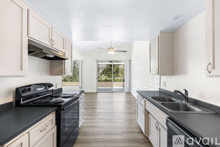 A kitchen with black countertops and white cabinets.