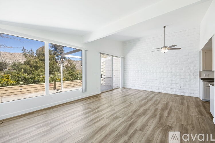 A room with wooden floors and a ceiling fan.
