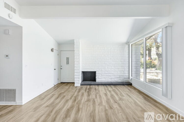 A spacious living room with a fireplace and wooden flooring.