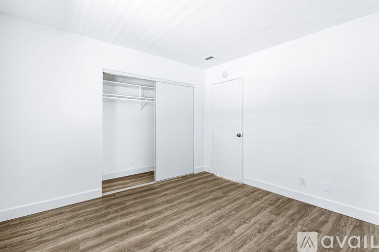 A room with a white wall and a wooden floor.
