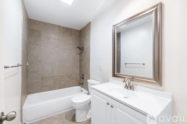A white bathroom with a tub, toilet and sink.