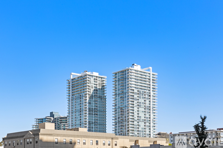 Two tall buildings with glass windows are in the foreground.