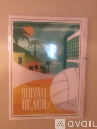 A framed picture of Hermosa Beach is hanging on a wall.