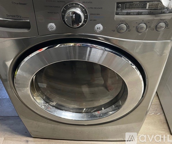 A front-loading washing machine with a digital control panel and a transparent door.