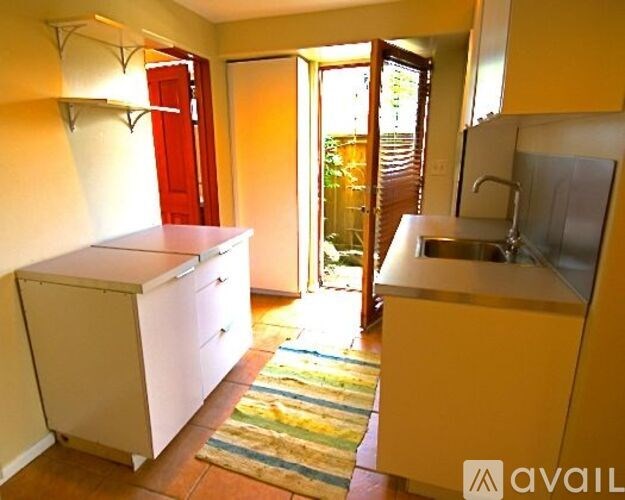 A kitchen with yellow cabinets and a white fridge.
