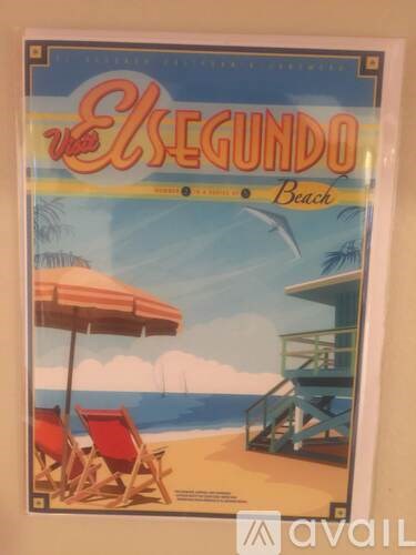 A poster of El Segundo Beach with beach chairs and an umbrella.