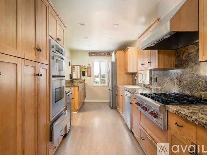 A kitchen with wooden cabinets and a granite countertop.