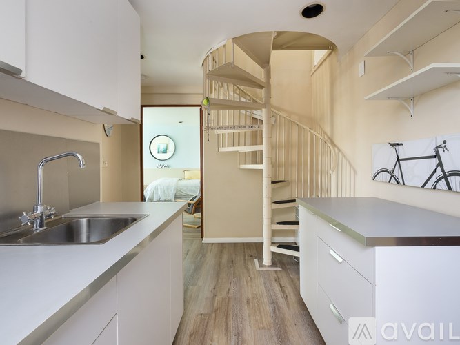 A modern kitchen with a spiral staircase in the middle.