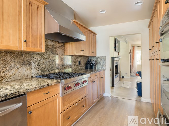 A kitchen with wooden cabinets and a granite countertop.