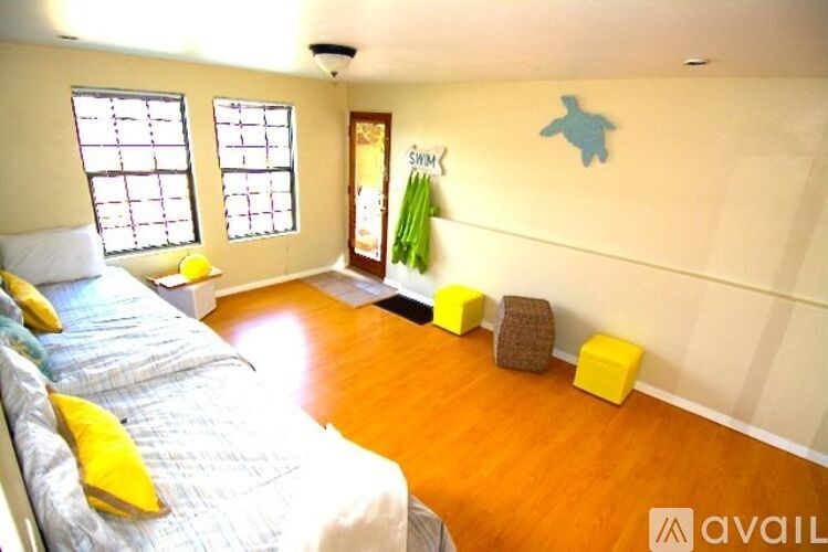 A bedroom with a bed, a window, and a wooden floor.