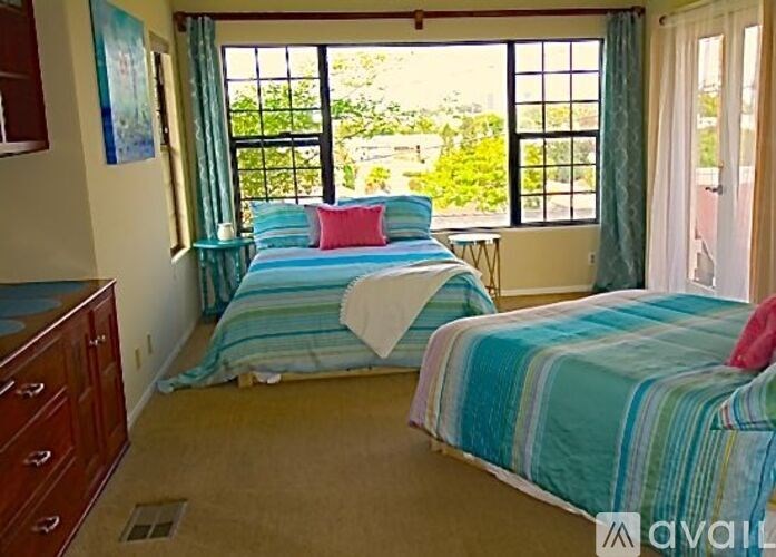 A bedroom with two beds and a dresser.