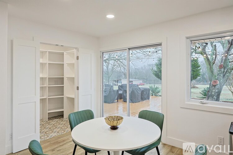 A dining room with a white table and green chairs.