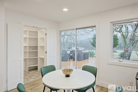 A dining room with a white table and green chairs.