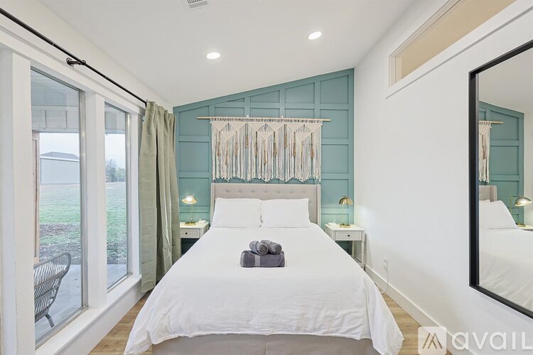 A bedroom with a large bed and a mirror on the wall.