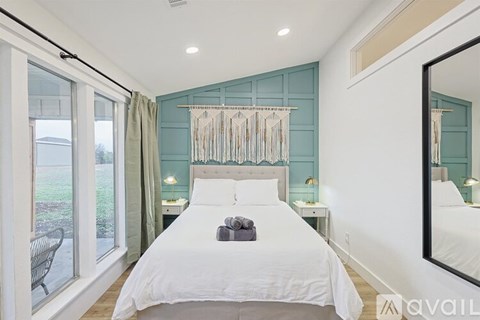 A bedroom with a large bed and a mirror on the wall.